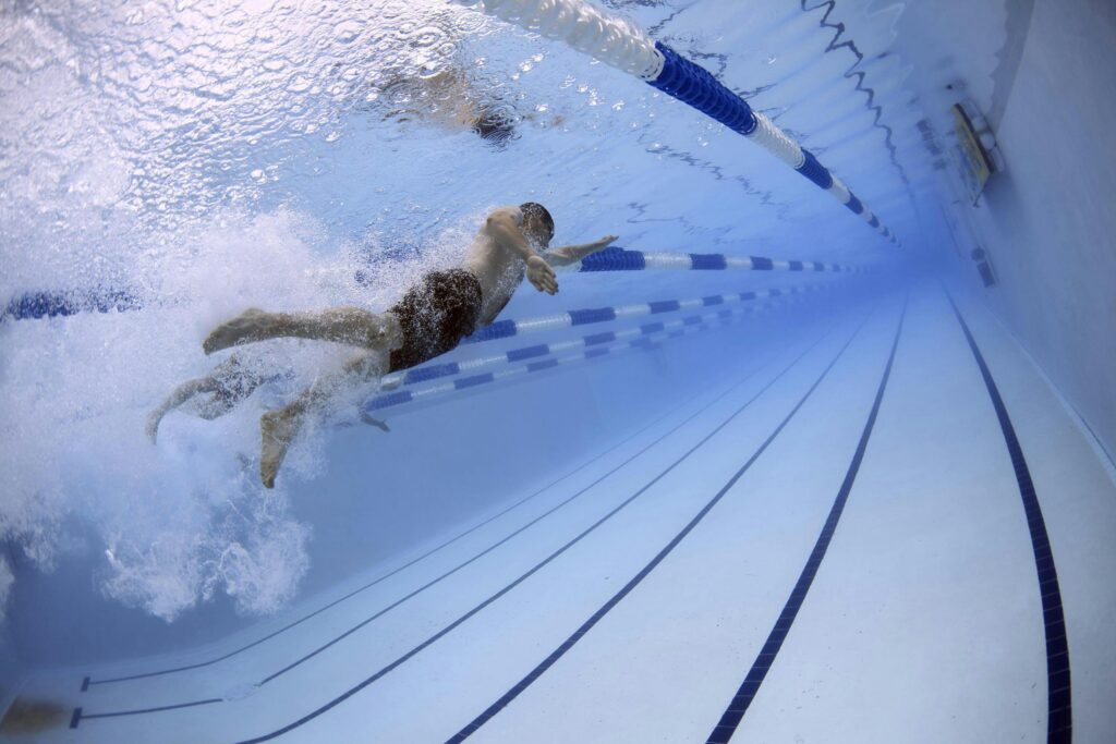 Key features of Hydrotherapy in Newcastle, Dynamic image of swimmers in an underwater pool race showcasing freestyle techniques.